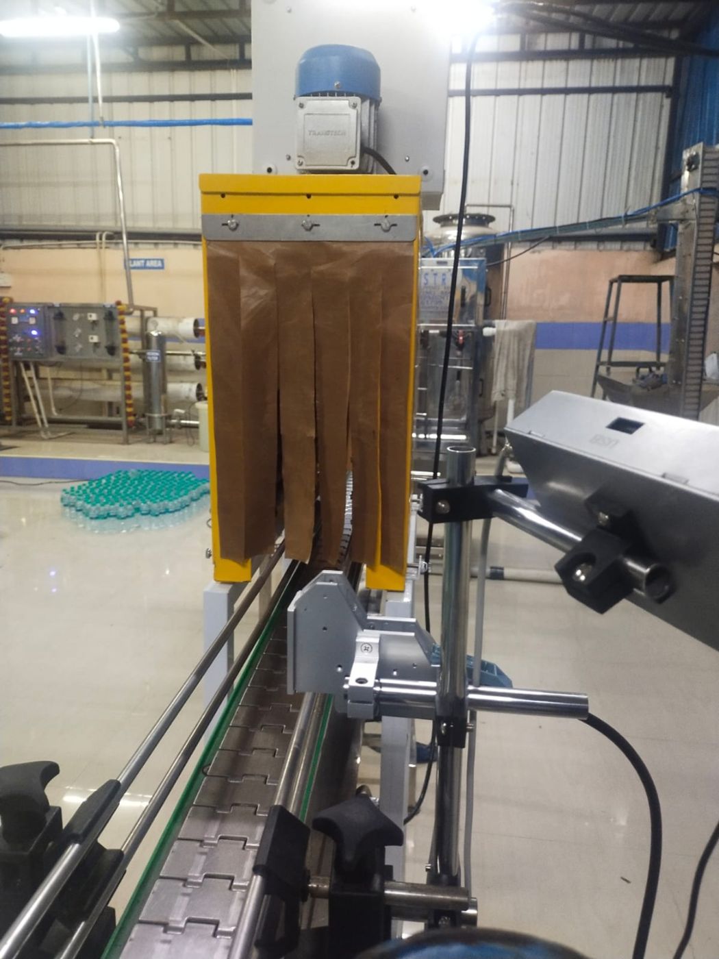 Bottle conveyor with shrink tunnel on a packaged drinking water line – PureFlux Engineering, Chennai